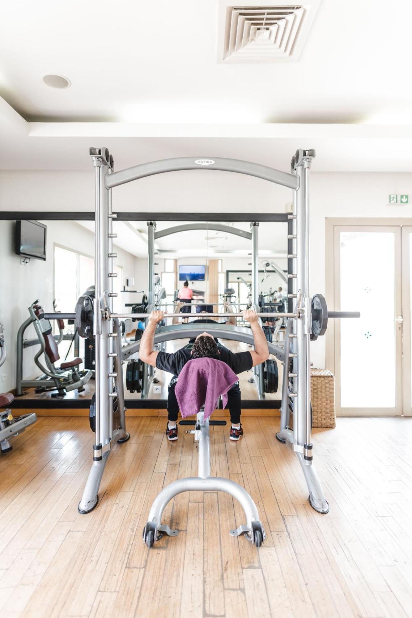 Kenzi Menara Palace & Resort Marrakesh Bagian luar foto A woman performing a bench press with a Smith machine